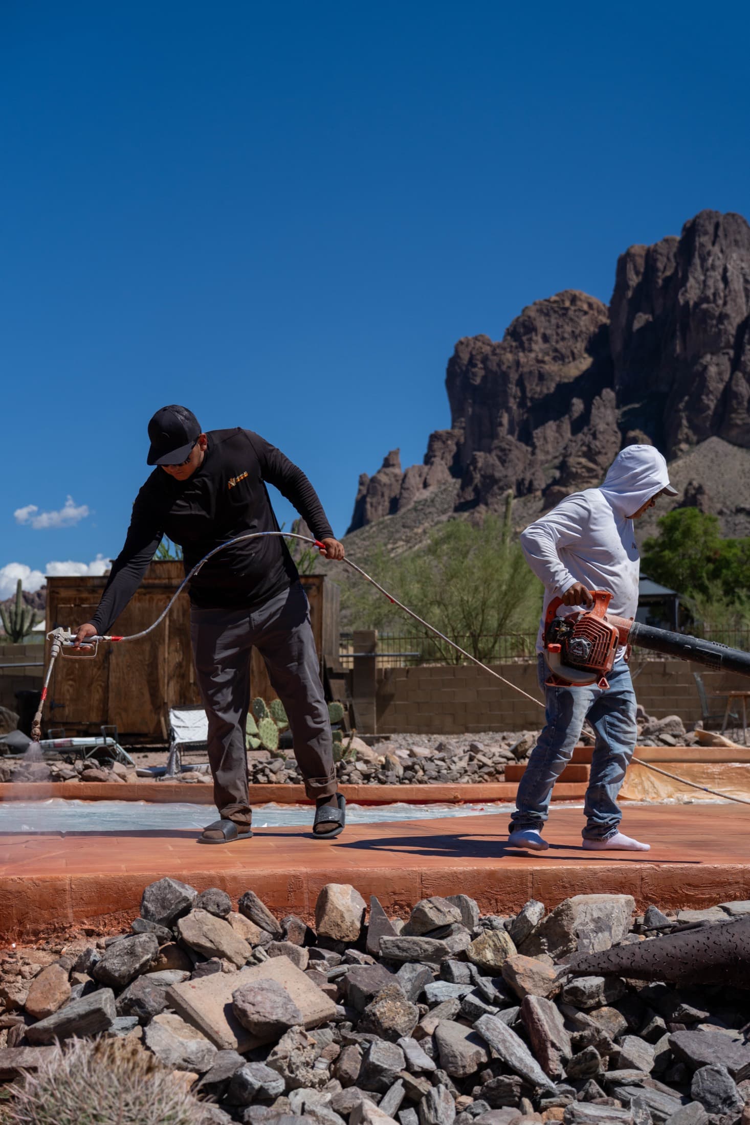 Acrylic Valley crew sealing a pool deck beneath the Superstition Mountains