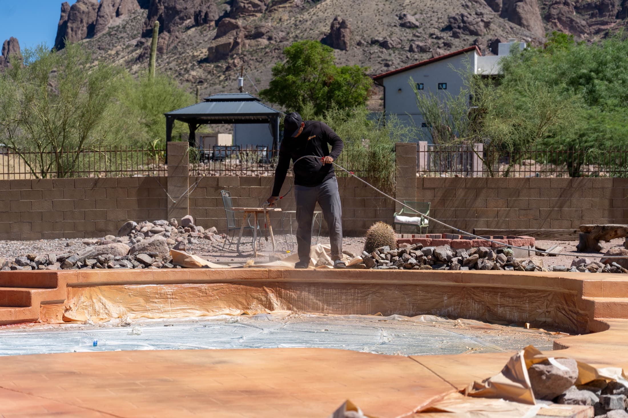 Acrylic Valley crew member spray-applying sealer to a freshly resurfaced pool deck