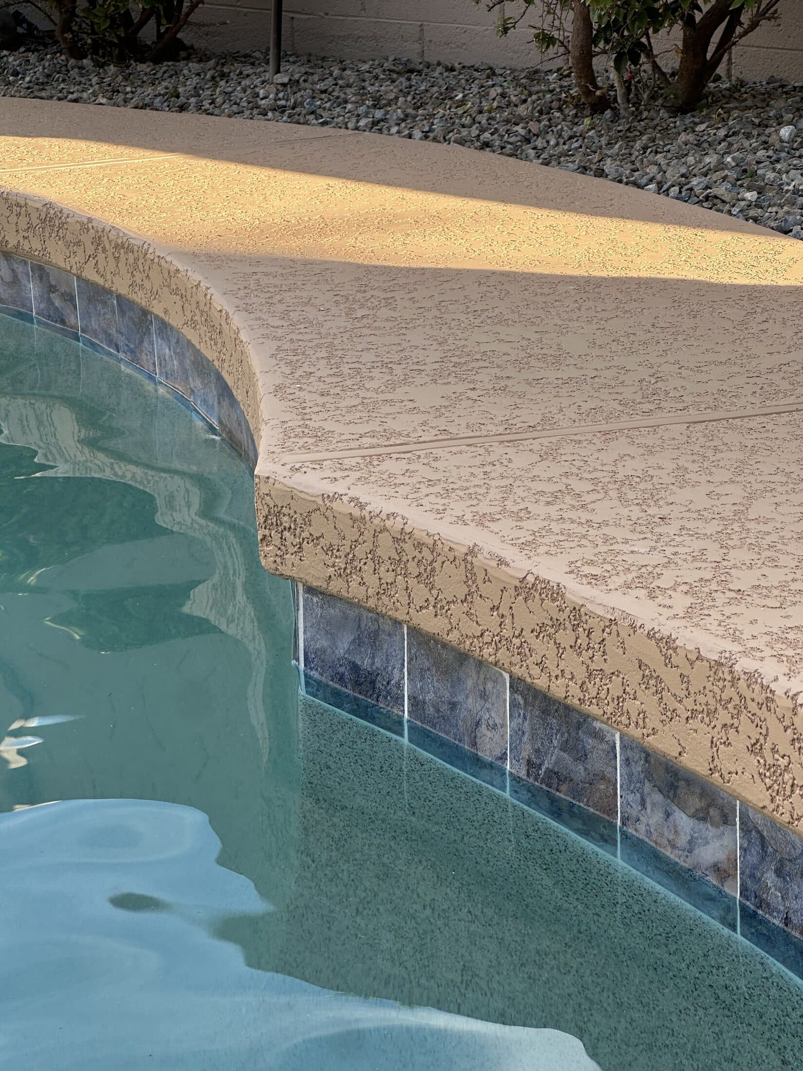 Close-up of resurfaced pool coping and cool deck texture