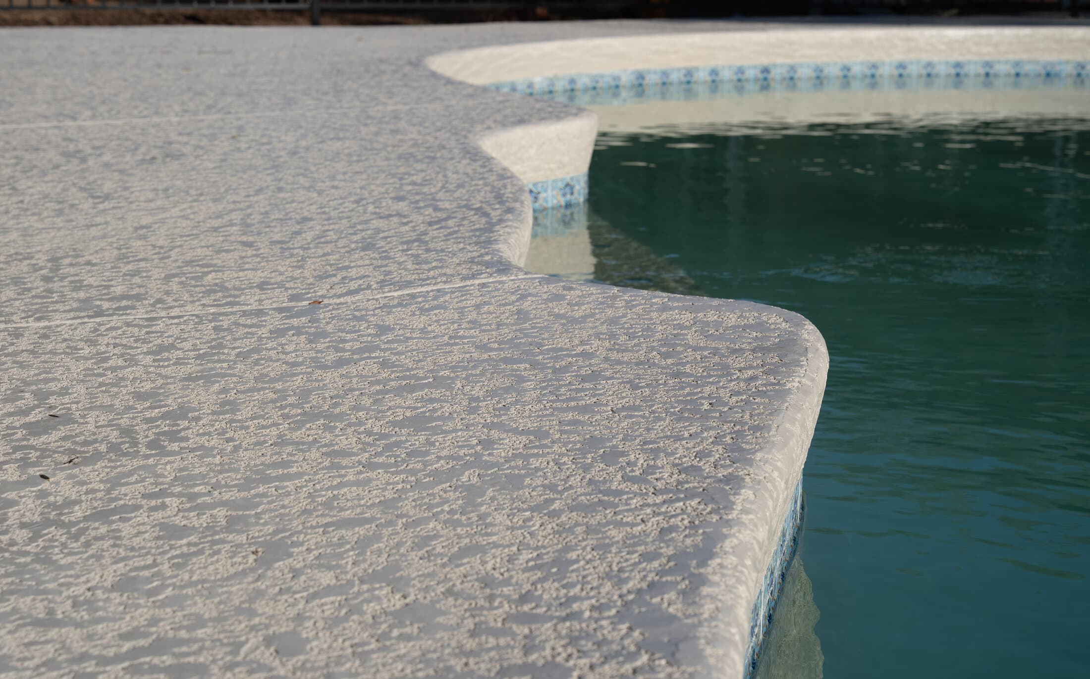Close-up of resurfaced pool deck coping detail