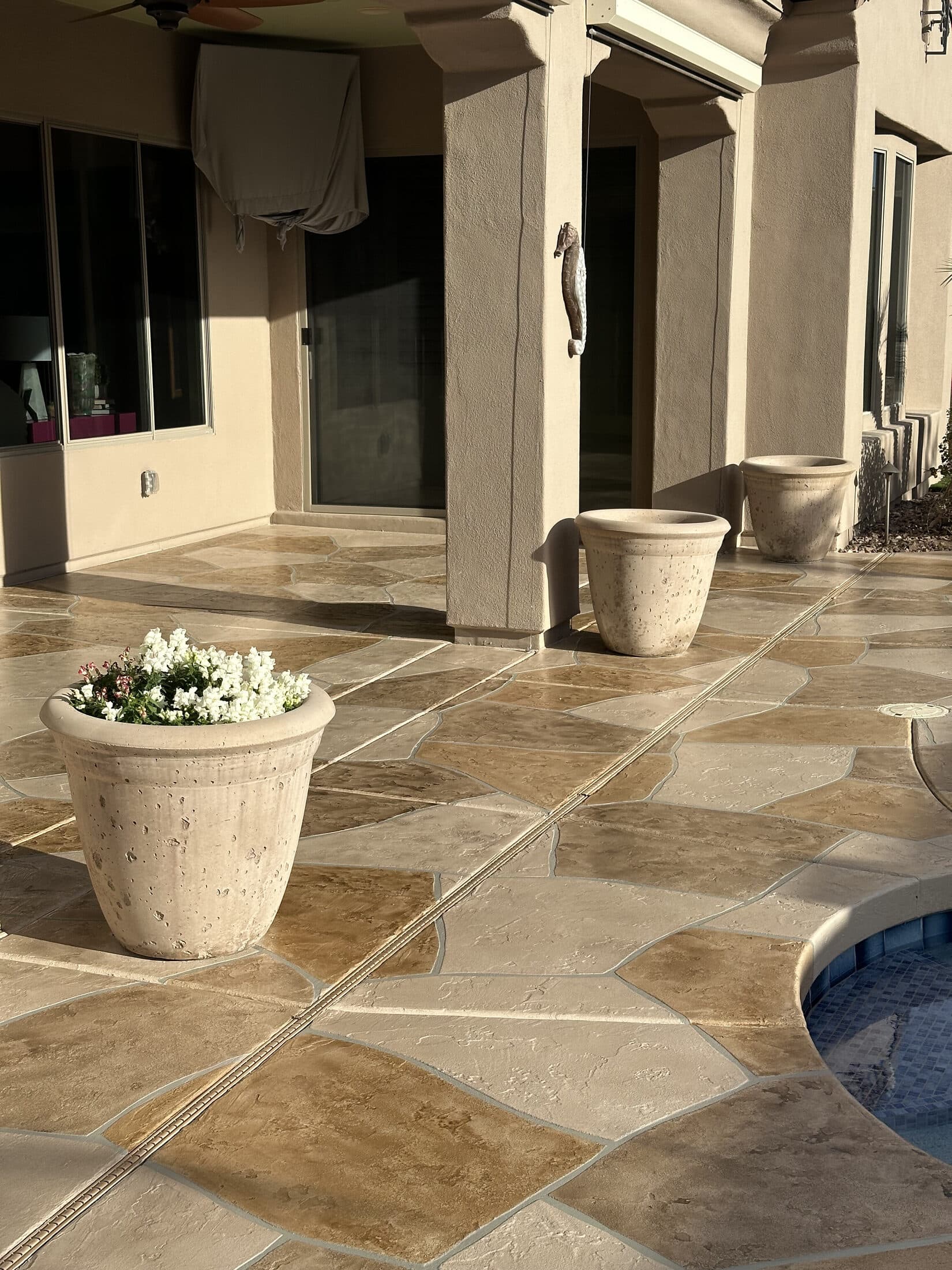 Flagstone-pattern stamped concrete overlay patio beside a Phoenix backyard pool