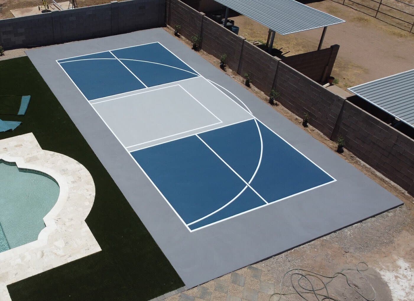 Aerial view of a custom backyard pickleball and basketball court next to a pool in Phoenix, AZ