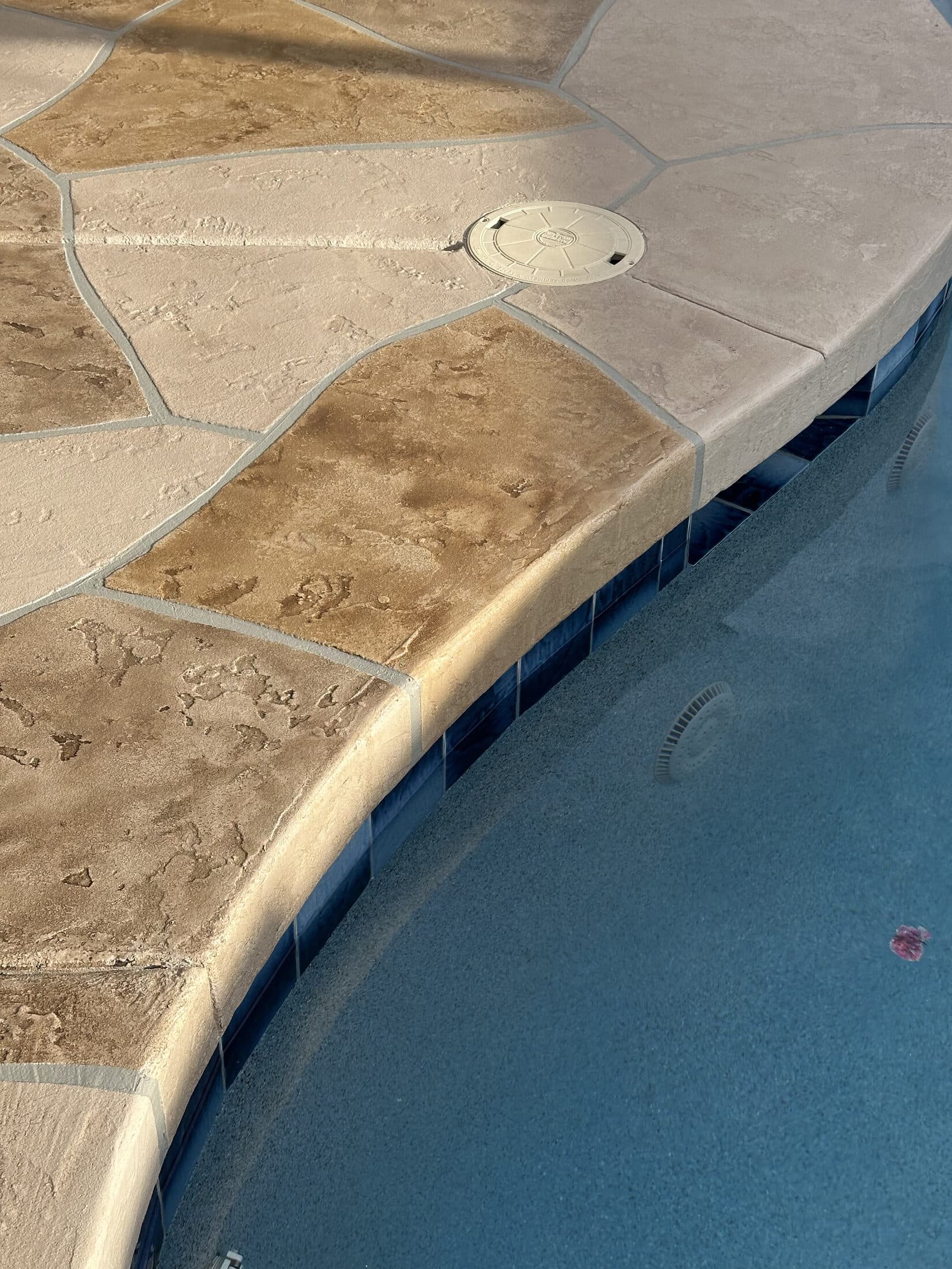Tan flagstone-pattern stamped concrete overlay patio